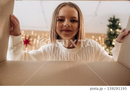 Curious girl is looking inside the gift box for presents. New year conception Curious girl is looking inside the gift box for presents. New year conception 139291193