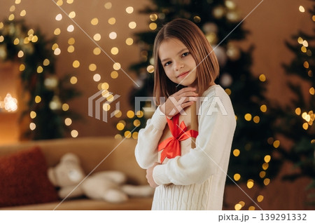 Got a gift box. Cute little girl is celebrating New Year at home in domestic room 139291332