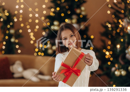 Got a gift box. Cute little girl is celebrating New Year at home in domestic room 139291336