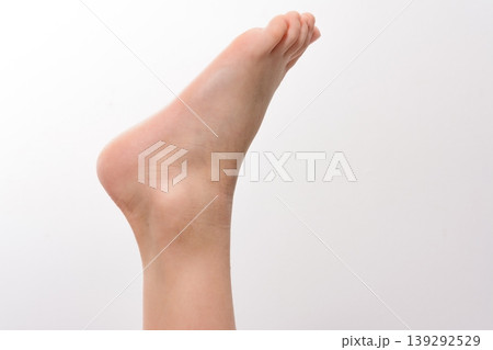 Close-up of a foot raised against a white background. Soft, smooth skin is visible. Perfect for healthcare or beauty. Close-up of a foot raised against a white background. Soft, smooth skin is visible. Perfect for healthcare or beauty. 139292529