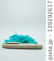 Front view of a lancing device pen and a pile of turquoise sterile blood lancets isolated on a white background 139292617
