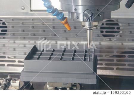 Precision CNC milling machine performing finishing process on a graphite electrode using a ball nose end mill. Precision CNC milling machine performing finishing process on a graphite electrode using a ball nose end mill. 139293160