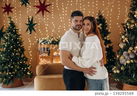 Couple standing in the Christmas style decorated room, conception of holidays and family Couple standing in the Christmas style decorated room, conception of holidays and family 139293589