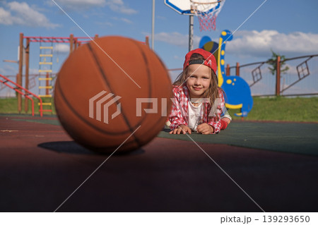 A basketball in the foreground and a child behind. Basketball Sports School for young children A basketball in the foreground and a child behind. Basketball Sports School for young children 139293650