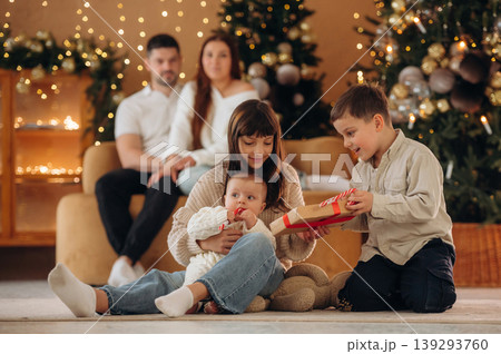 The kids are playing. Happy family is celebrating the Christmas in the holidays decorated room The kids are playing. Happy family is celebrating the Christmas in the holidays decorated room 139293760