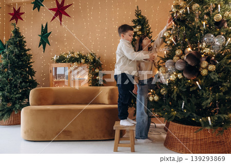 Sister and brother are decorating Christmas tree at home together Sister and brother are decorating Christmas tree at home together 139293869