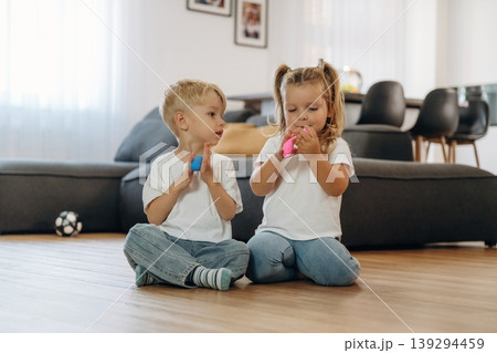 Plasticine in hands. Little kids are playing together in the domestic room at daytime 139294459