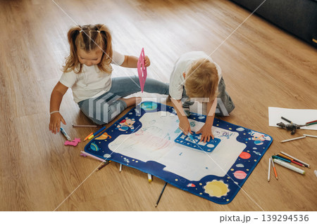 Many of the markers, drawing. Little kids are playing together in the domestic room at daytime Many of the markers, drawing. Little kids are playing together in the domestic room at daytime 139294536