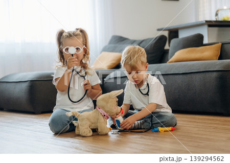 Cute plush toy, using stethoscope. Little kids are playing together in the domestic room at daytime 139294562