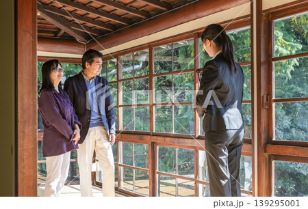古民家の室内を案内する女性ガイドとシニア夫婦 古民家の室内を案内する女性ガイドとシニア夫婦 139295001