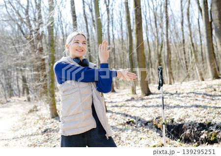 Young woman stretching arms before nordic walking in forest Young woman stretching arms before nordic walking in forest 139295251