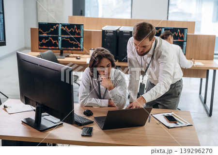 Thinking, talking the strategy. Two male exchange workers are in the office together Thinking, talking the strategy. Two male exchange workers are in the office together 139296270