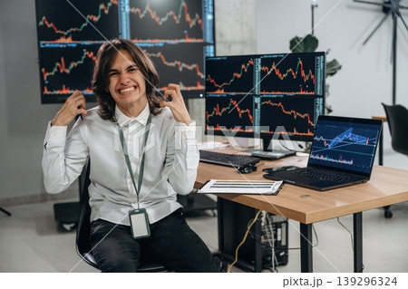 Young man is sitting in the office with multiple displays of stock market data 139296324