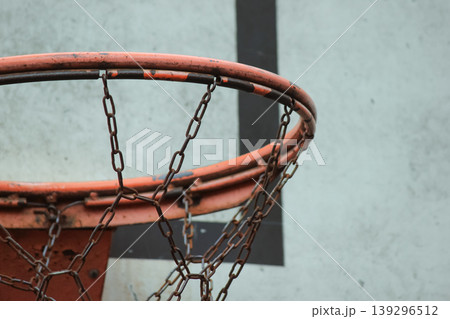 Detailed close up of a weathered basketball hoop rim with a durable chain net against a backboard Detailed close up of a weathered basketball hoop rim with a durable chain net against a backboard 139296512