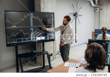 Big screen, showing data. Business people are working with stock market exchange in office Big screen, showing data. Business people are working with stock market exchange in office 139296785