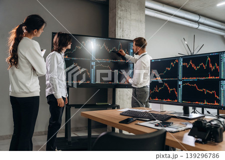 Big screen, showing data. Business people are working with stock market exchange in office Big screen, showing data. Business people are working with stock market exchange in office 139296786