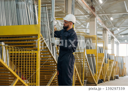 Row of yellow colored parts. Warehouse worker in an industrial environment of a factory or storage area Row of yellow colored parts. Warehouse worker in an industrial environment of a factory or storage area 139297339
