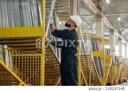 Bunch of raw windows parts. Warehouse worker in an industrial environment of a factory or storage area Bunch of raw windows parts. Warehouse worker in an industrial environment of a factory or storage area 139297340
