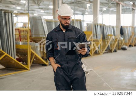 Bunch of raw windows parts. Warehouse worker in an industrial environment of a factory or storage area Bunch of raw windows parts. Warehouse worker in an industrial environment of a factory or storage area 139297344