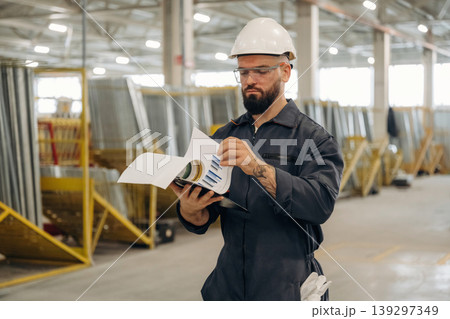 Reading the information from the document. Warehouse worker in an industrial environment of a factory or storage area 139297349