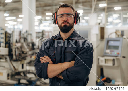 In protective headphones. Warehouse worker in an industrial environment of a factory or storage area In protective headphones. Warehouse worker in an industrial environment of a factory or storage area 139297361