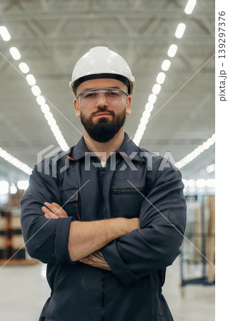 Guy is standing and posing. Warehouse worker in an industrial environment of a factory or storage area 139297376