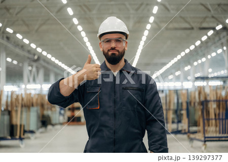 Guy is standing and posing. Warehouse worker in an industrial environment of a factory or storage area 139297377