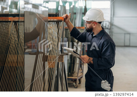 Confident look, quality control. Warehouse worker in an industrial environment of a factory or storage area Confident look, quality control. Warehouse worker in an industrial environment of a factory or storage area 139297414