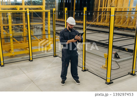 Holding digital tablet. Warehouse worker in an industrial environment of a factory or storage area 139297453