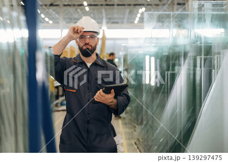 Production conception, quality control. Warehouse worker in an industrial environment of a factory or storage area Production conception, quality control. Warehouse worker in an industrial environment of a factory or storage area 139297475