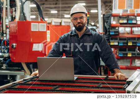 Silver colored laptop, using it. Warehouse worker in an industrial environment of a factory or storage area Silver colored laptop, using it. Warehouse worker in an industrial environment of a factory or storage area 139297519