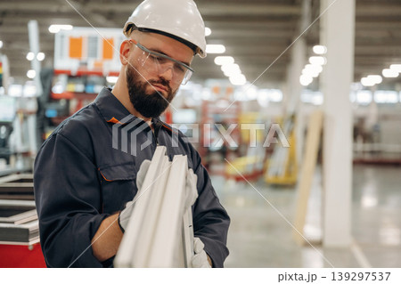 Checking quality of small window border. Warehouse worker in an industrial environment of a factory or storage area Checking quality of small window border. Warehouse worker in an industrial environment of a factory or storage area 139297537