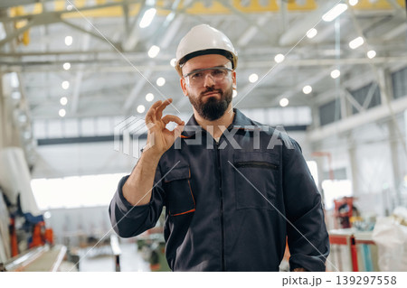 Okay hand gesture. Warehouse worker in an industrial environment of a factory or storage area Okay hand gesture. Warehouse worker in an industrial environment of a factory or storage area 139297558