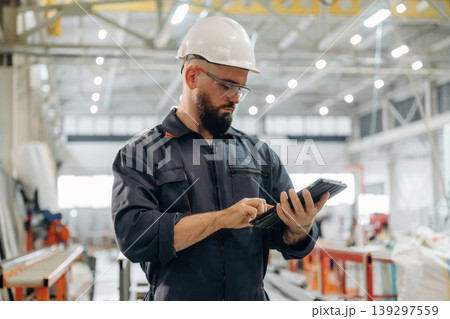 Important data, reading. Warehouse worker in an industrial environment of a factory or storage area Important data, reading. Warehouse worker in an industrial environment of a factory or storage area 139297559