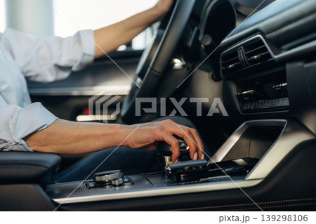 Using the control panel. Detailed close up view of woman that is driving the new car 139298106
