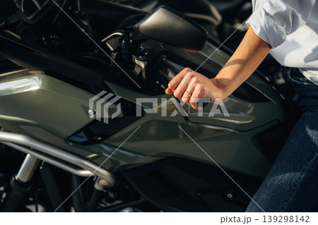An woman is sitting on the motorcycle, illuminated by a sunlight An woman is sitting on the motorcycle, illuminated by a sunlight 139298142