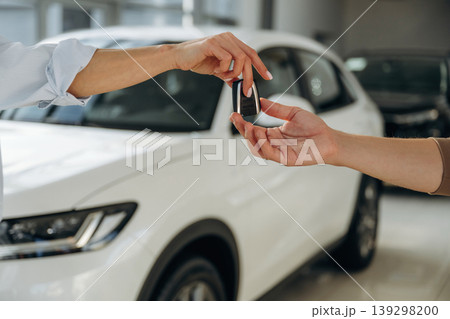 Close up view of woman's and man's hands that are taking the keys for new car Close up view of woman's and man's hands that are taking the keys for new car 139298200