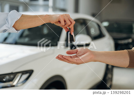 Close up view of woman's and man's hands that are taking the keys for new car Close up view of woman's and man's hands that are taking the keys for new car 139298201