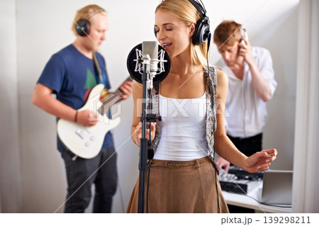Professional, musician and woman with microphone, headphones and band performance with talent. Recording studio, art and girl singer live streaming for music record label, sound and audio broadcast. Professional, musician and woman with microphone, headphones and band performance with talent. Recording studio, art and girl singer live streaming for music record label, sound and audio broadcast. 139298211