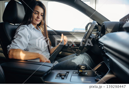 Wearing the safety belt. Woman is sitting in the modern car, happy new owner 139298447