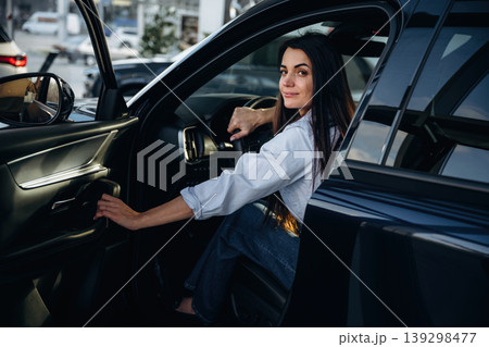Closing the door. Woman is sitting in the modern car, happy new owner 139298477