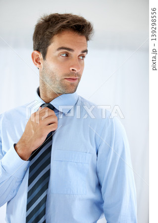 Job opportunity, tie and a business person getting ready for work in studio on a white background. Corporate, company and dressing with a young man adjusting his outfit for a professional career 139298556
