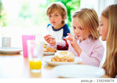 Family, morning and breakfast jam, children and meal for nutrition, orange juice and bagel. Brother, sisters and enjoying food together for hunger, health and energy for home weekend activities 139298679