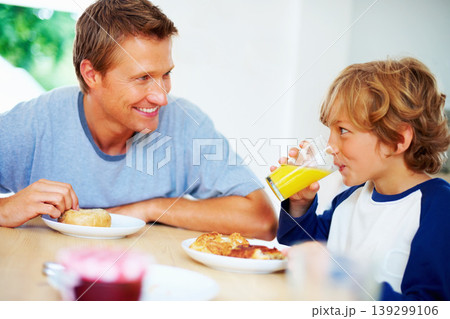 Happy family, morning and breakfast on weekend, looking and eating for nutrition, orange juice and donut. Father, child and enjoying food together for hunger, health and energy for good day Happy family, morning and breakfast on weekend, looking and eating for nutrition, orange juice and donut. Father, child and enjoying food together for hunger, health and energy for good day 139299106