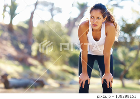 Thinking, fitness and tired woman in a park for workout break, recovery or resting after cardio run. Sports, fatigue and female runner stop to breathe in a forest for wellness, training or exercise 139299153