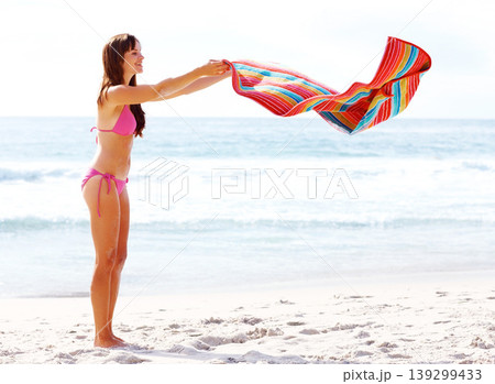 Woman, happy and towel on sand at beach for relax, freedom and sunshine with swimwear outdoor in summer. Person, smile and swimsuit by ocean with swimming, peace and wellness on holiday or vacation Woman, happy and towel on sand at beach for relax, freedom and sunshine with swimwear outdoor in summer. Person, smile and swimsuit by ocean with swimming, peace and wellness on holiday or vacation 139299433
