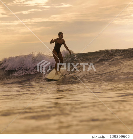 Woman Surfs Sunset, Sunset Illuminates Ocean As Woman Surfs Closer Woman Surfs Sunset, Sunset Illuminates Ocean As Woman Surfs Closer 139299606