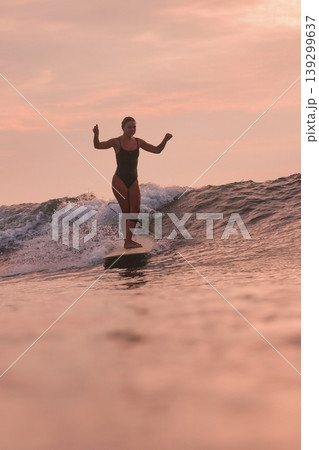 Confident Female Surfer Calmly Handles Gentle Coastal Surf At Dusk Confident Female Surfer Calmly Handles Gentle Coastal Surf At Dusk 139299637