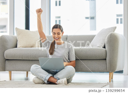 Winner woman, laptop and fist on floor for success, goal or bonus in trading, stock market or deal. Girl, computer and happy in home living room for cheers, invest or yes for profit, revenue or lotto 139299654