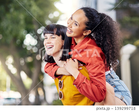 Couple of friends, lesbian and piggyback outdoor for fun, travel and happiness or love on vacation. Young female people in a city for holiday or playful trip with a smile and joy to hangout in summer 139299718